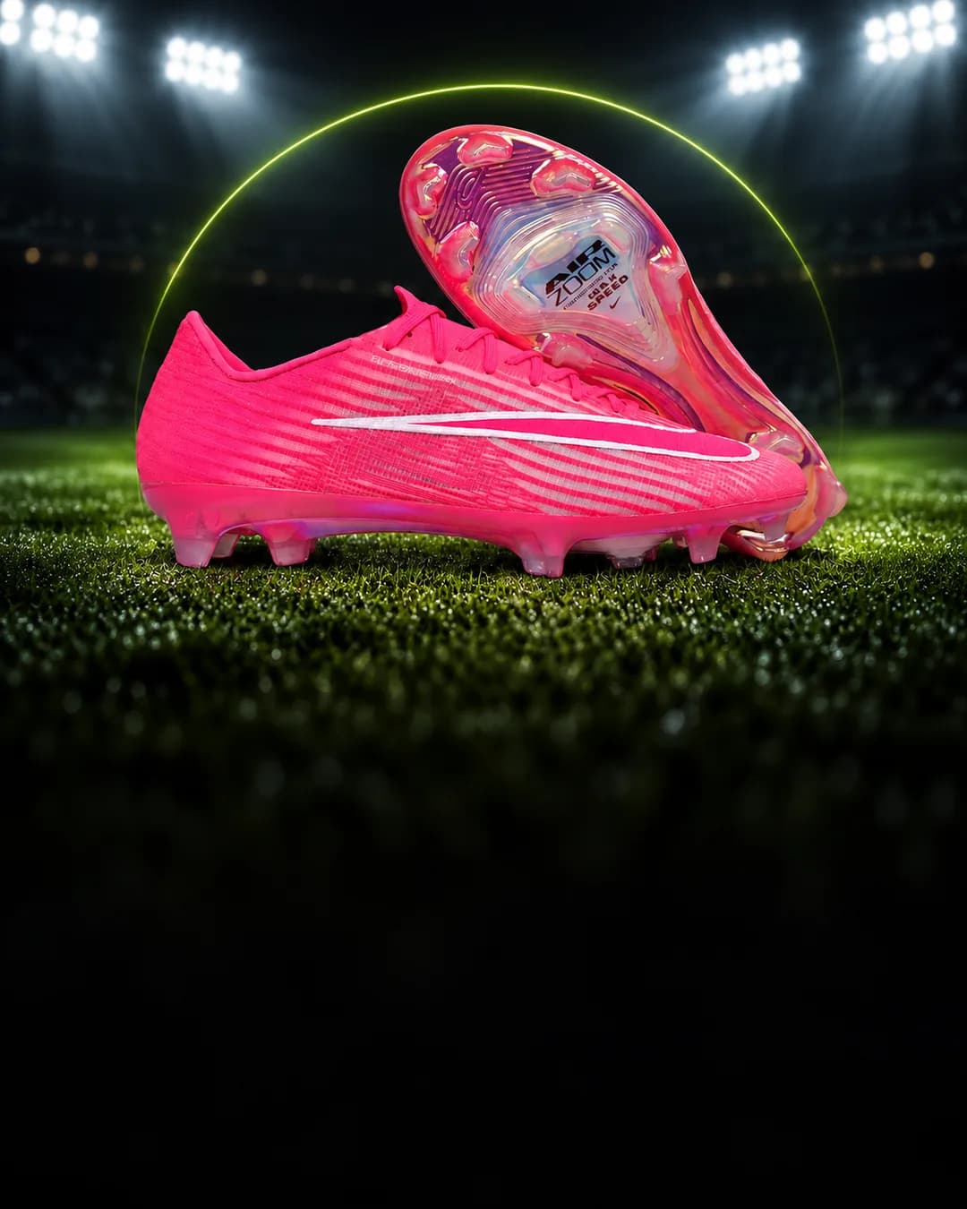 Chuteira Nike Mercurial rosa no gramado de um estádio à noite, com o arco verde-limão da Arena