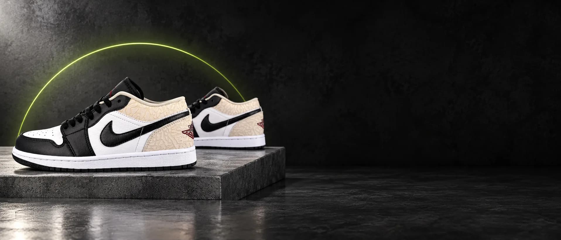 Par de Nike Air Jordan 1 Low preto, branco e bege sobre um bloco de concreto, com o arco verde-limão da Arena